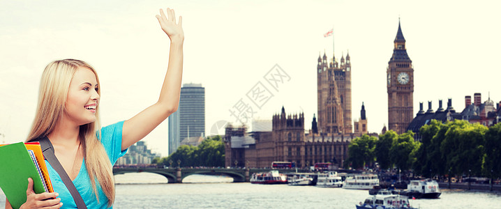 教育,学校,出国留学,手势人的微笑的学生与文件夹挥舞着移交伦敦城泰晤士河背景图片