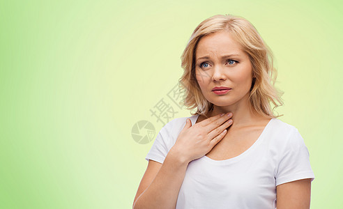 人,医疗保健问题快乐的女人触摸她的脖子喉咙疼痛的绿色自然背景图片
