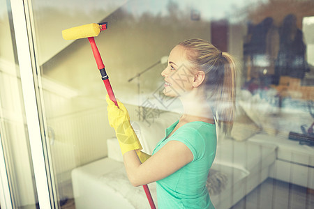 人,家务家务快乐的女人戴着手套,家里用海绵拖把擦窗户图片
