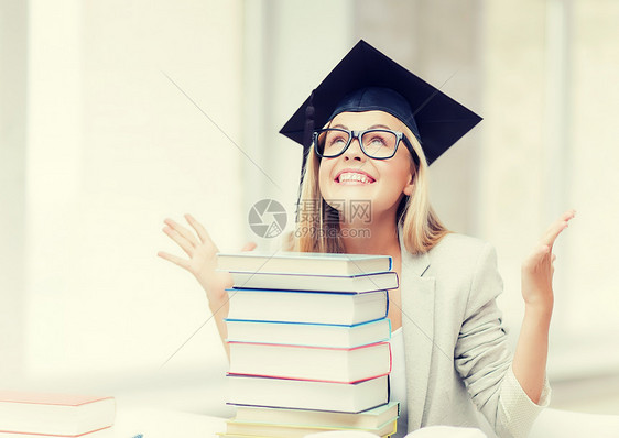 带着叠书的毕业帽里的快乐学生毕业帽里的快乐学生图片