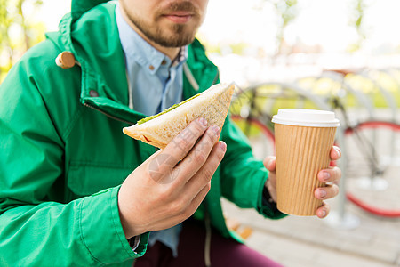 人们,垃圾食品,饮食生活方式靠近轻人的咖啡杯三明治城市街道上吃喝图片
