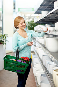 人,园艺,购物,销售消费观念快乐的女人与篮子选择花盆商店图片