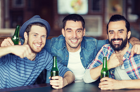 人休闲友谊单身汉聚会的快乐的男朋友酒吧酒吧喝瓶装啤酒拥抱图片