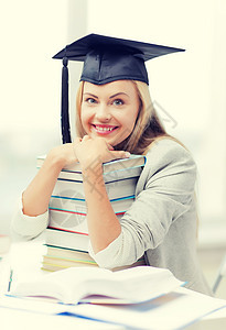 带着叠书的毕业帽里快乐的学生的照片戴毕业帽的学生图片