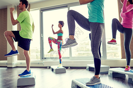 健身,运动,健美操人的群微笑的人健身房的台阶平台上锻炼抬腿图片