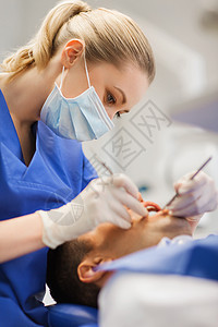人,医学,口腔医学保健女牙医与牙科镜探头检查男病人牙齿牙科诊所办公室图片