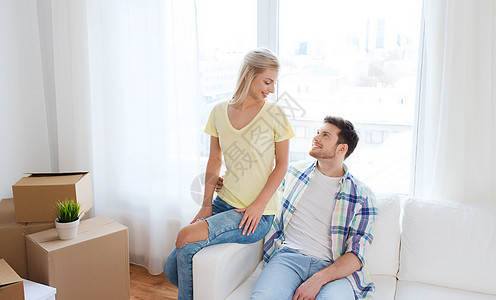 移动,人,维修房地产幸福的夫妇与大纸板箱沙发上的新家图片