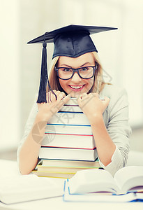 带着叠书的毕业帽里快乐的学生的照片戴毕业帽的学生图片