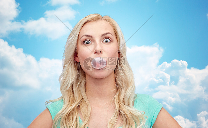 情感表情人的快乐的轻女人十几岁的女孩蓝天云彩背景上嚼口香糖图片