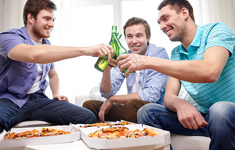 友谊,酒精,人,庆祝节日的亲密的快乐男朋友家里碰啤酒瓶吃比萨饼图片