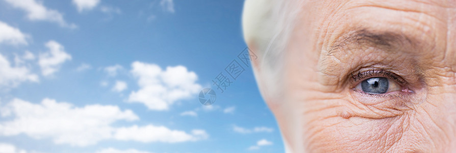 龄,视力,视力老人的特写老妇女的脸眼睛蓝天云彩的背景图片