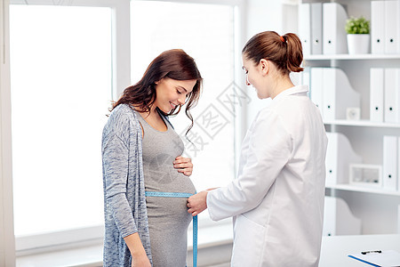 怀孕,妇科,医学,保健人的妇科医生用厘米胶带测量孕妇医院的肚子图片