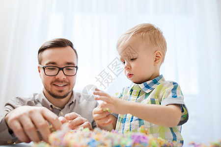 家庭,童,创造力,活动人的快乐的父亲小儿子家里玩球粘土图片