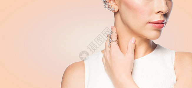 魅力,美丽,珠宝豪华美丽的女人与金色戒指钻石耳环米色背景图片