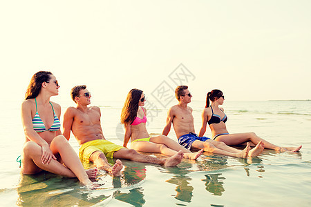 友谊,海洋,暑假,假期人们的群微笑的朋友穿着泳装太阳镜坐海滩上的水中图片