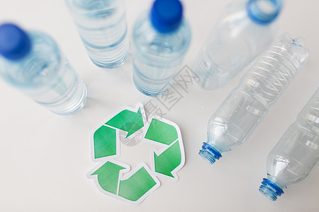回收,再利用,垃圾处理,环境生态空塑料瓶与绿色回收符号桌子上背景图片
