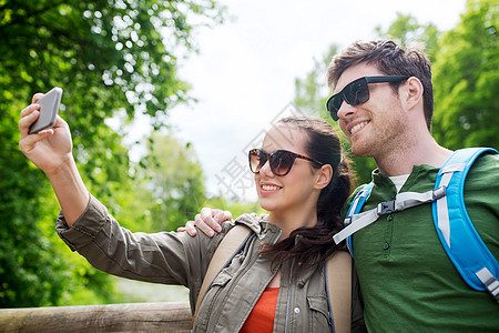 旅行,徒步旅行,背包,旅游人的微笑夫妇与背包采取自拍智能手机自然界图片