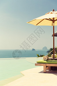 旅行,度假,旅游豪华美丽的风景无限边缘游泳池与阳伞海边图片