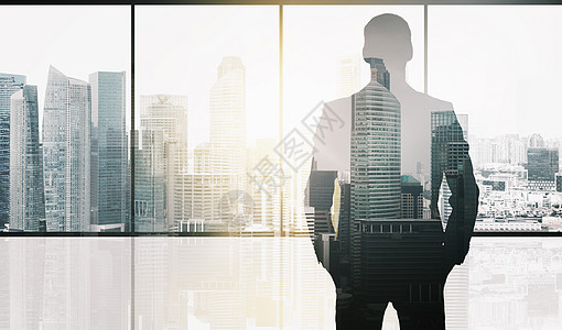 商业人的商人的轮廓办公室窗口新加坡城市摩天大楼的背景阳光双曝光效果办公室背景下商人的剪影图片