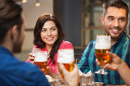 休闲,饮食,食物饮料,人假日的微笑的朋友餐馆酒吧吃晚餐喝啤酒背景图片