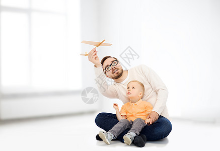 家庭,童,父亲,休闲人的快乐的父亲小儿子玩玩具飞机白色的房间背景图片
