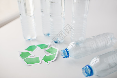 回收,再利用,垃圾处理,环境生态空塑料瓶与绿色回收符号桌子上背景图片