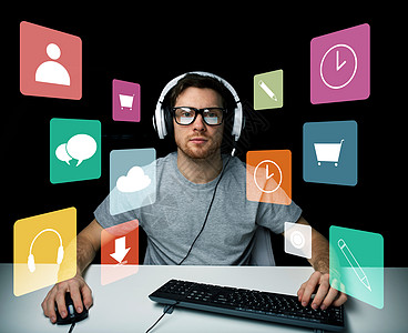 耳机图标技术,媒体人的轻人黑客耳机眼镜坐桌子上,电脑键盘菜单图标虚拟屏幕上背景