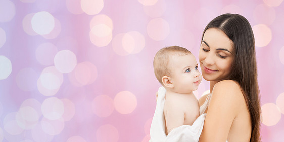 家庭,母亲,养育,人儿童保育的快乐的母亲抱着可爱的婴儿紫罗兰色的灯光背景图片