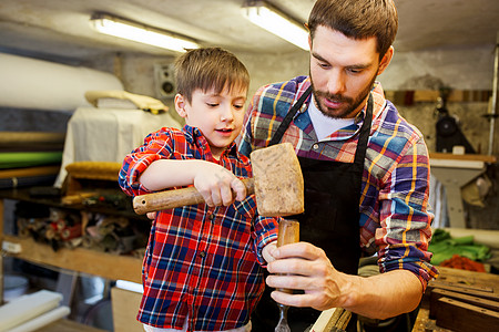 家庭,木工,木工人的父亲小儿子用凿子车间用木板工作图片