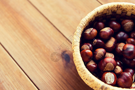 栗子板栗自然,季节,秋天植物学的栗子柳条篮子木制桌子上背景