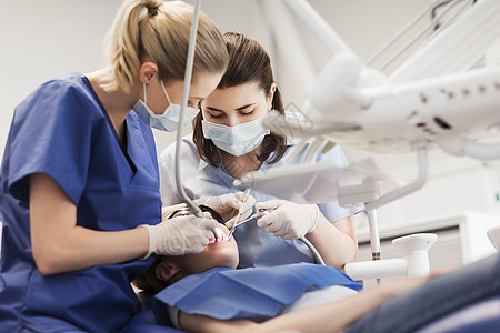 人,医学,口腔医学保健女牙医用镜子,钻探针治疗病人女孩牙齿牙科诊所办公室背景图片