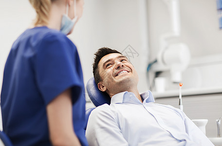 人,医学,口腔医学保健女牙医牙科诊所办公室与快乐的男病人交谈图片