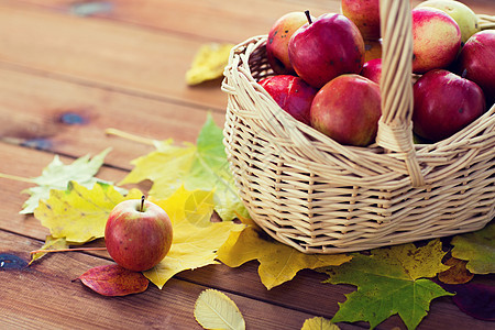 园艺,季节,秋天水果的柳条篮子与成熟的红色苹果树叶木桌上图片