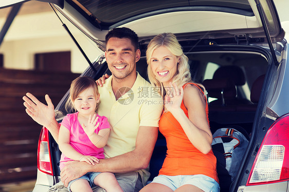 交通休闲公路旅行人们的快乐的家庭,小女孩坐掀背车的后备箱上,家里的停车位挥手图片