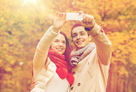 爱,关系,家庭人的微笑的夫妇拥抱自拍秋天的公园图片