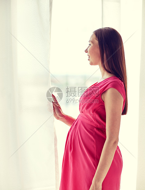 怀孕,母亲,人期望的快乐的孕妇大肚子透过窗户看家