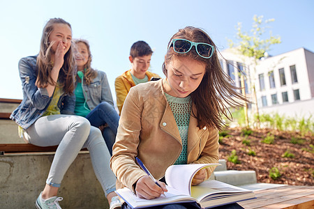 教育,欺凌,高中,社会关系人的快乐的学生女孩与书中的同学遭受嘲弄图片