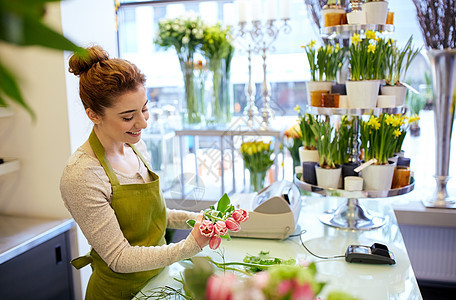 人,商业,销售花卉快乐微笑的花店妇女花店制作郁金香图片