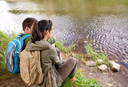旅行,徒步旅行,背包旅行,旅游人的夫妇背包坐湖边河岸图片