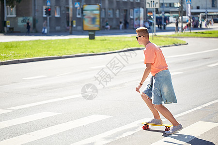 暑假,极限运动人的十几岁的男孩骑着短现代巡洋舰滑板城市人行横道图片