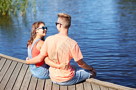 假期,爱人的快乐的十几岁的夫妇坐河泊夏天拥抱图片