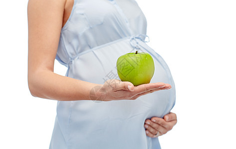 怀孕,健康饮食,食物人的密切孕妇持绿色苹果白色背景图片
