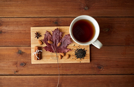 秋天季节的杯茶,枫叶杏仁木板上图片
