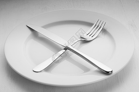 叉子刀子躺空白盘子上盘子上的餐具图片