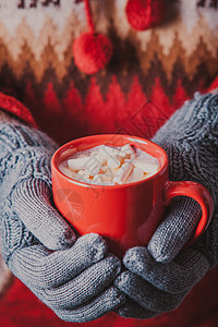 温暖的冬天照片,双手戴着针手套,着个带棉花糖的杯子可可带棉花糖的可可图片