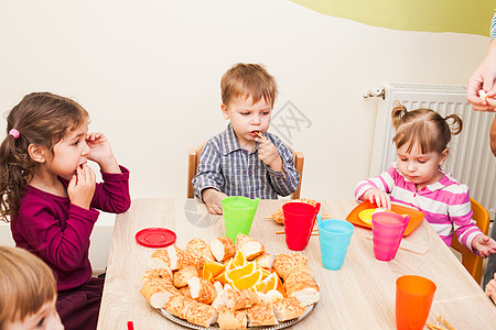 孩子吃饭孩子们坐桌子旁吃午饭,吃水果蛋糕幼儿园吃午饭背景