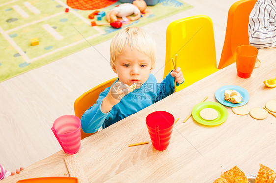 孩子们坐桌子旁吃午饭,吃水果蛋糕幼儿园吃午饭图片