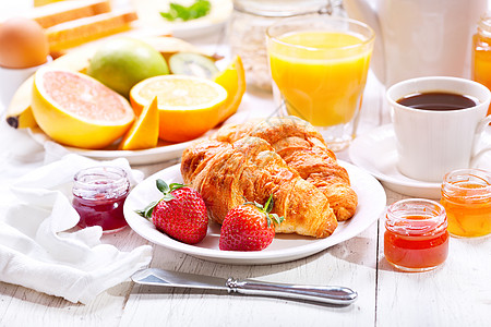 早餐桌上牛角包咖啡橙汁烤包水果图片