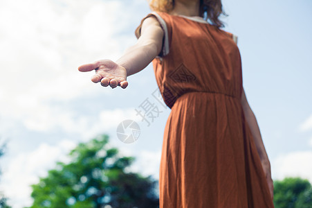 个轻的女人阳光明媚的日子里站外,伸出援手图片