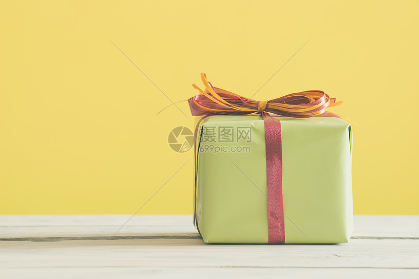 绿色礼物,桌子上条红色橙色的丝带图片